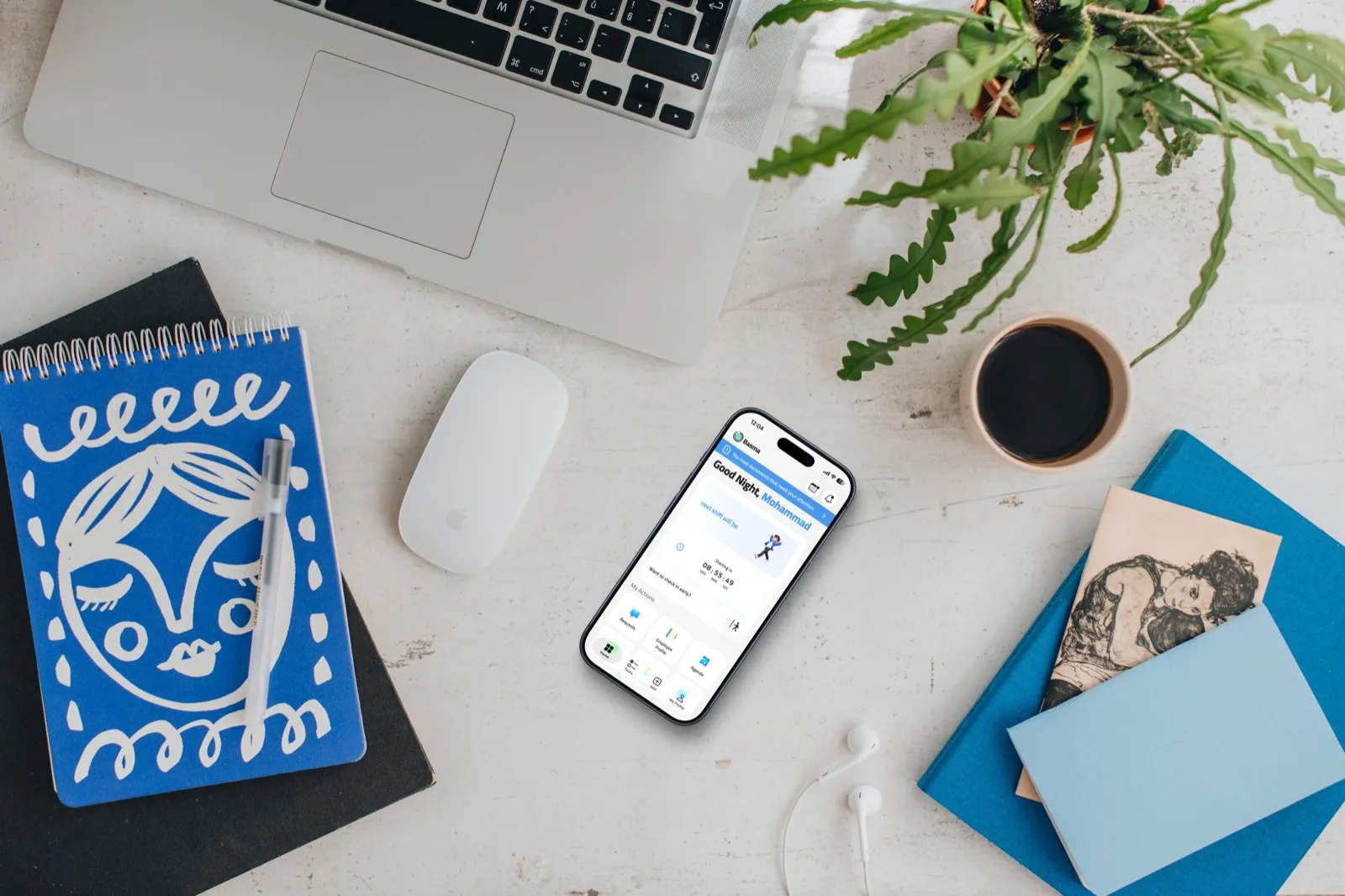 The Basma app open on a phone at a workspace desk